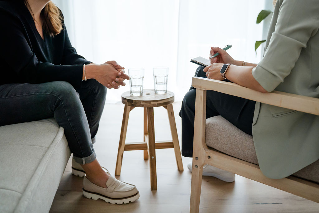 Ausschnitt Hände, Tisch mit Gläsern Coach und Coachee im Gespräch